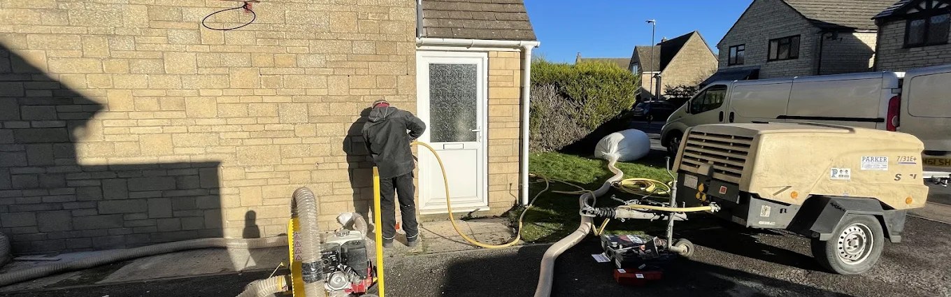 FCE extraction team on site with vacuum unit, compressor and hoses, cavity wall extraction in progress