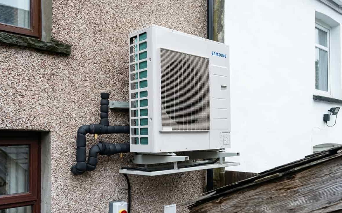 Air source heat pump unit mounted on exterior wall